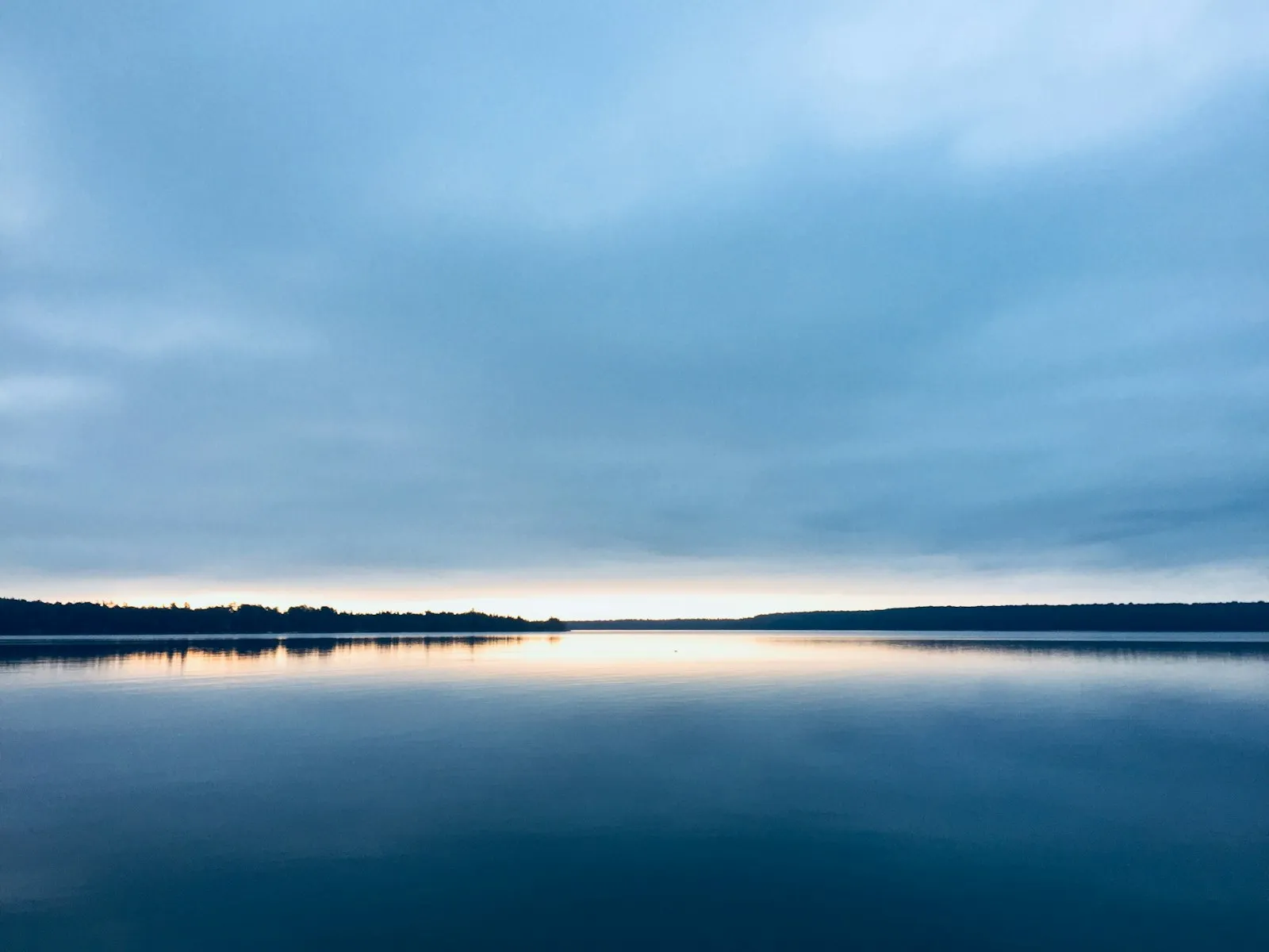 A wide, still lake at sunset