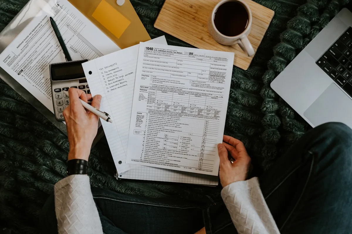 Working through a household financial plan with documents, calculator and coffee Working through a household financial plan with documents, calculator and coffee